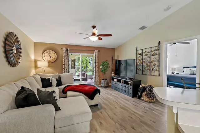 a living room with furniture a flat screen tv and a large window