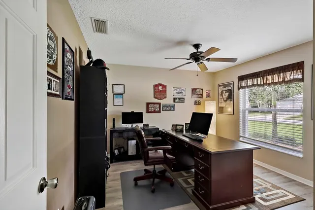 a view of a workspace with furniture and a window