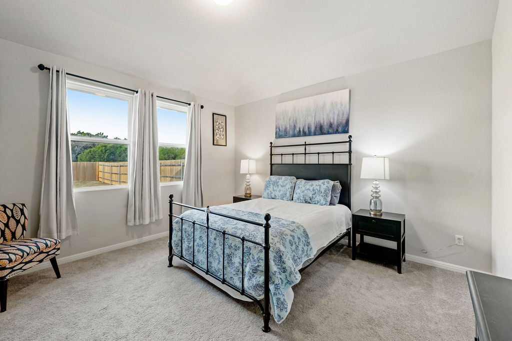 2417 Roosevelt Road Leander, TX 78641 - Photo 14 of 40 a bedroom with a bed lamp and window