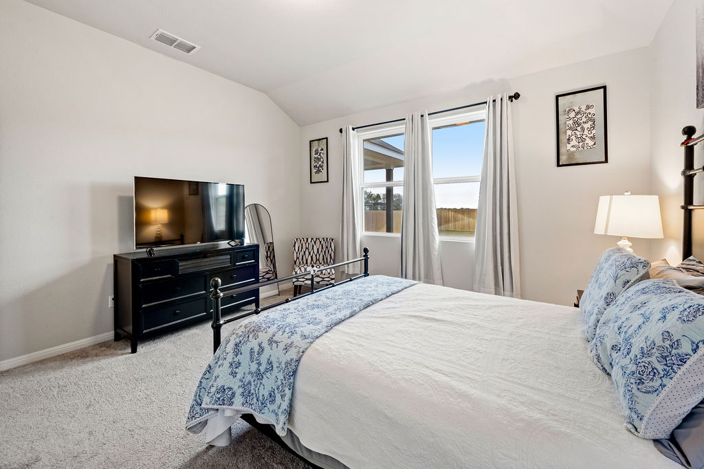 2417 Roosevelt Road Leander, TX 78641 - Photo 15 of 40 a bedroom with a bed and a flat screen tv