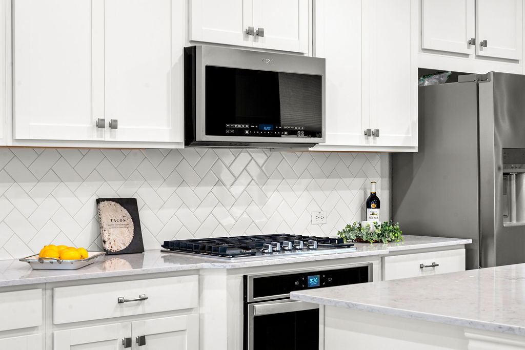 2417 Roosevelt Road Leander, TX 78641 - Photo 2 of 40 a kitchen with stainless steel appliances granite countertop a stove a microwave and cabinets