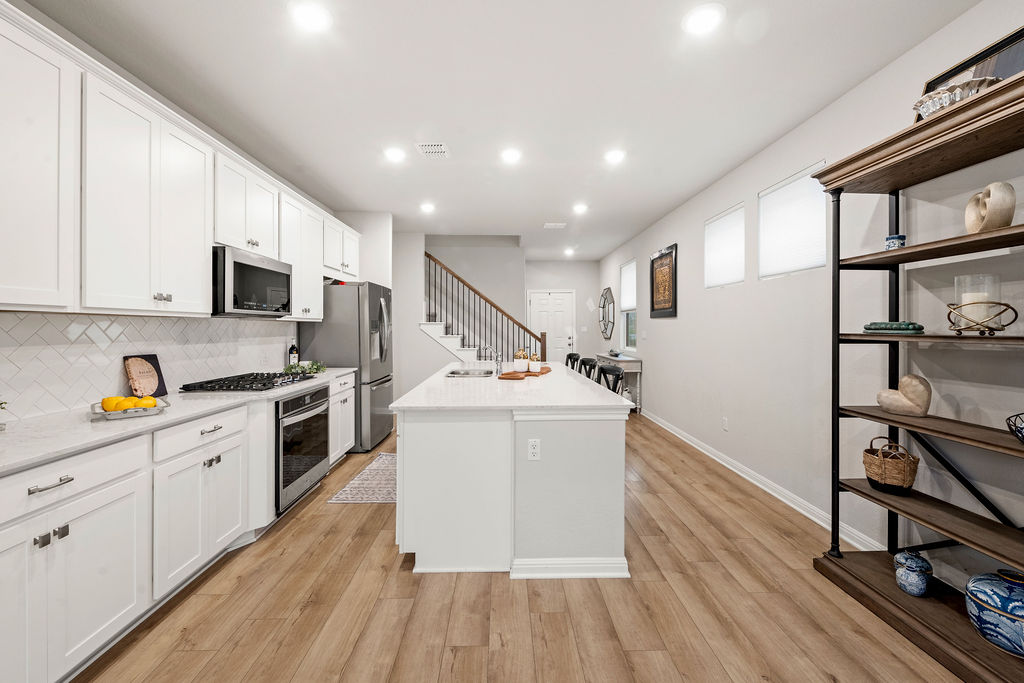 2417 Roosevelt Road Leander, TX 78641 - Photo 10 of 40 a kitchen with a sink appliances wooden floor and cabinets