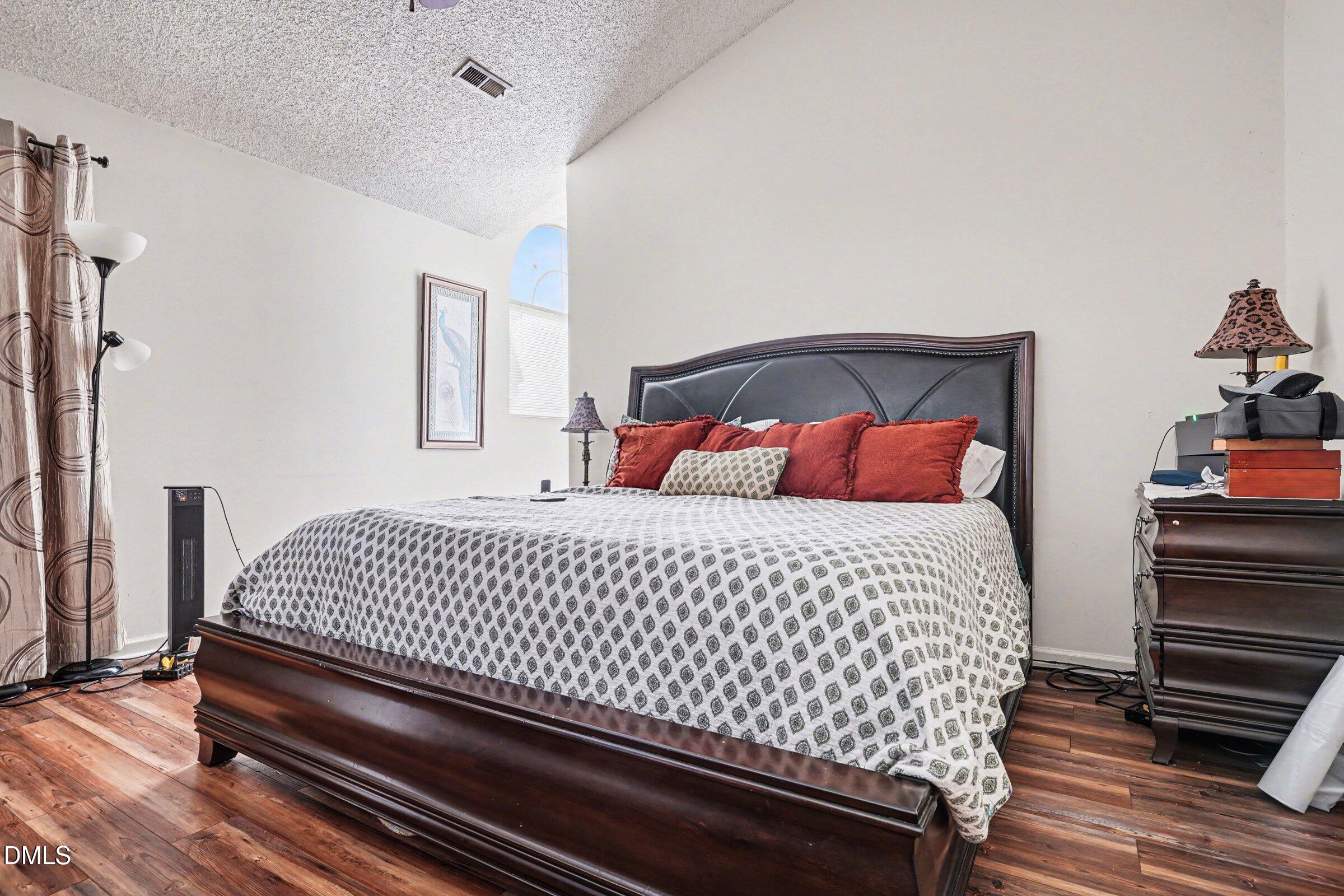 3806 Grey Harbor Drive, Unit 204 Raleigh, NC 27616 - Photo 12 of 18 a bedroom with a bed and wooden floor