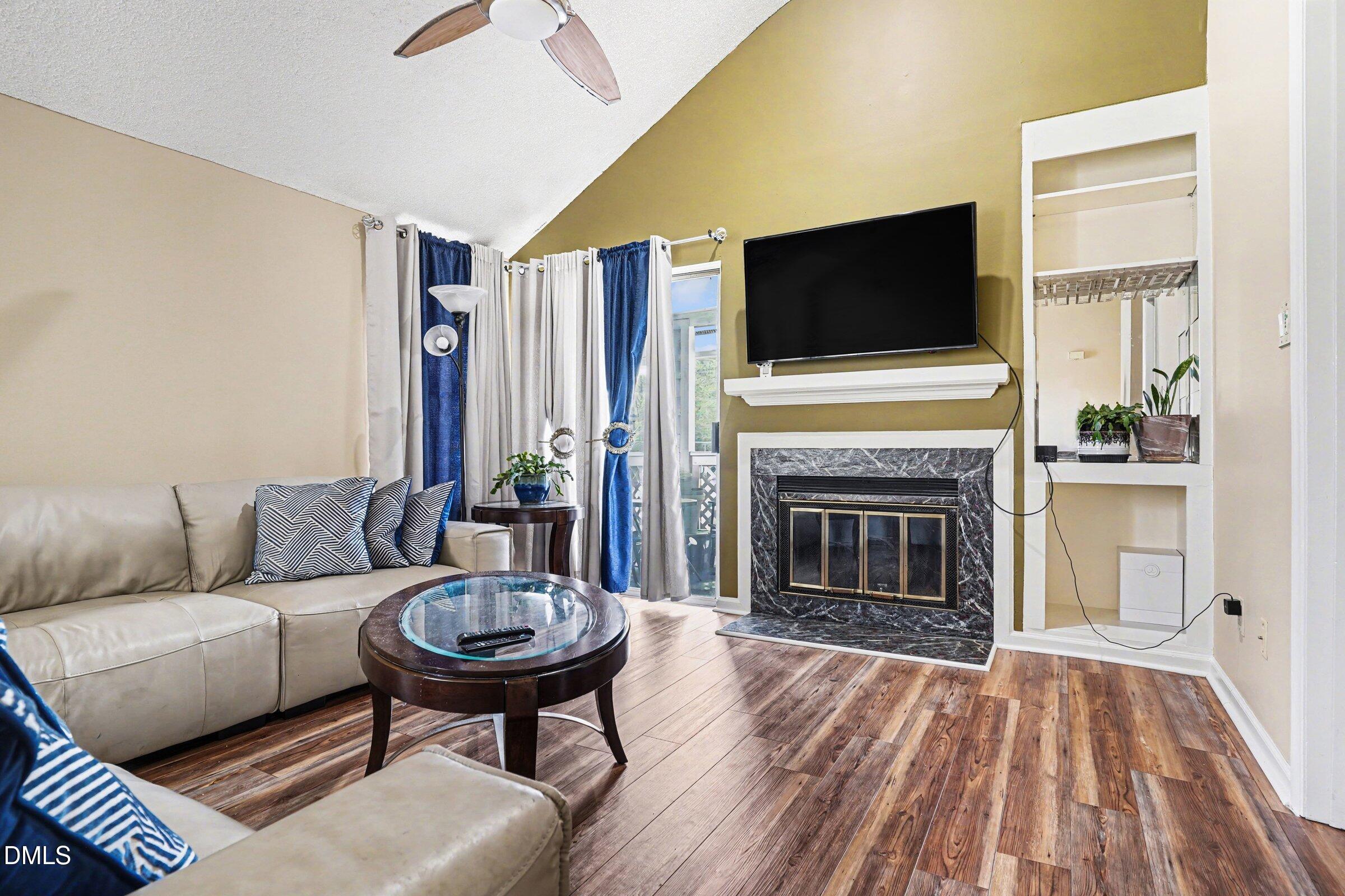 3806 Grey Harbor Drive, Unit 204 Raleigh, NC 27616 - Photo 6 of 18 a living room with furniture a flat screen tv and a fireplace