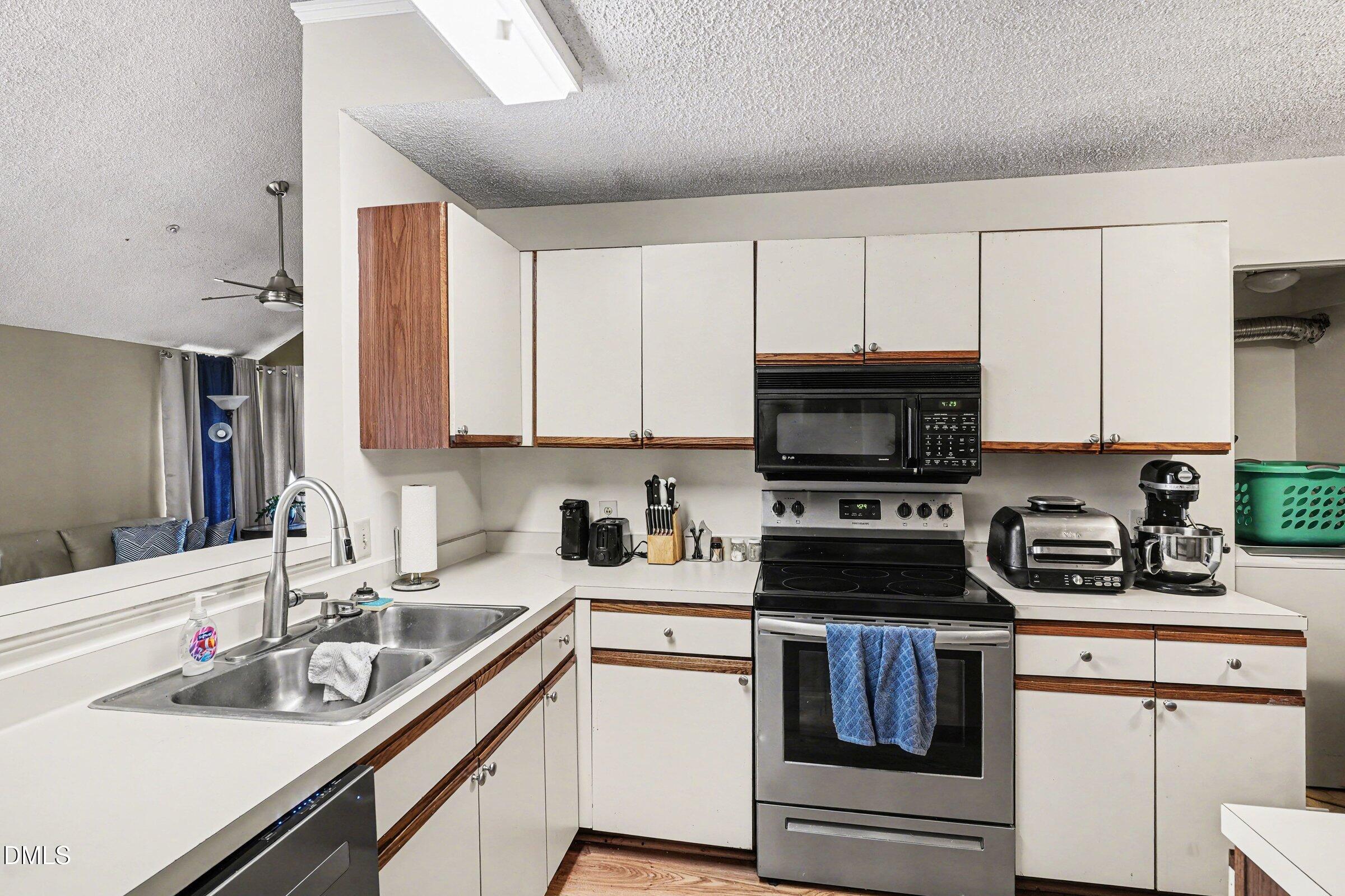 3806 Grey Harbor Drive, Unit 204 Raleigh, NC 27616 - Photo 8 of 18 a kitchen with a sink a stove and cabinets