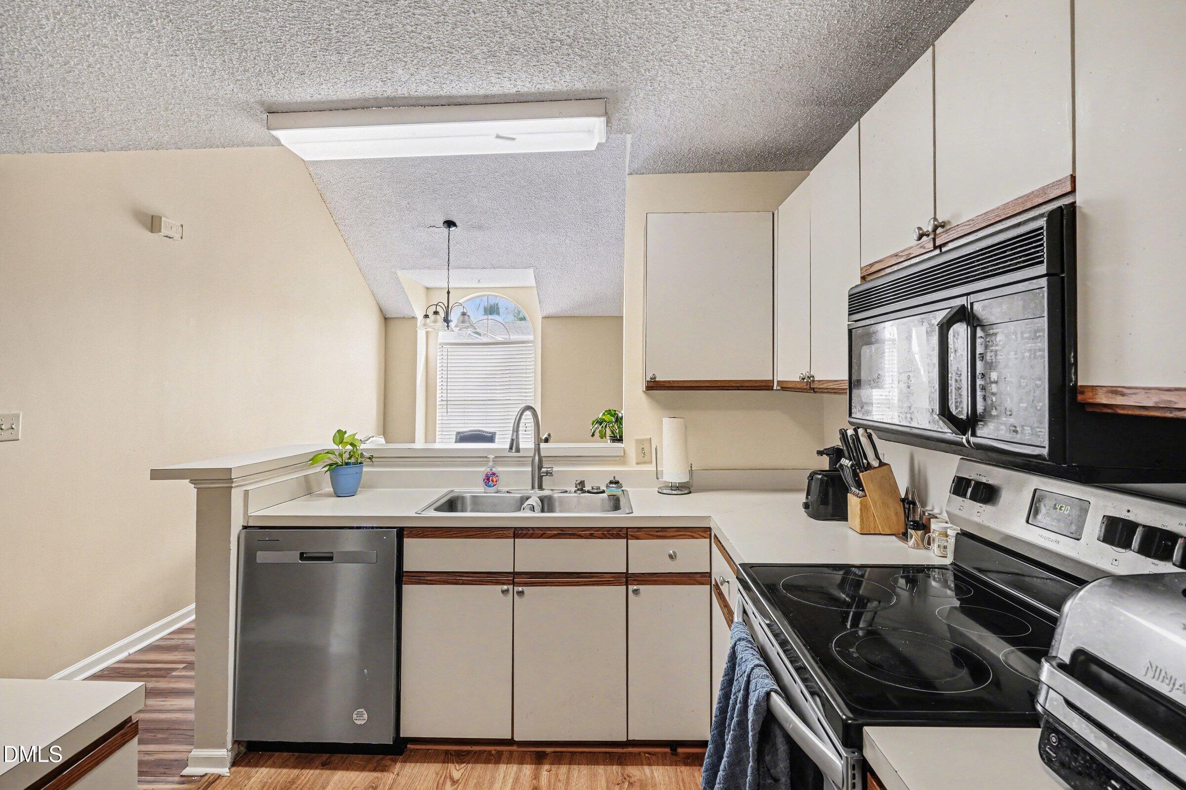 3806 Grey Harbor Drive, Unit 204 Raleigh, NC 27616 - Photo 9 of 18 a kitchen with a sink stove and microwave