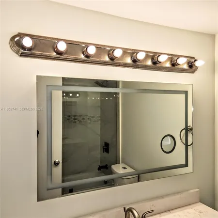a bathroom with a toilet a sink a mirror and vanity