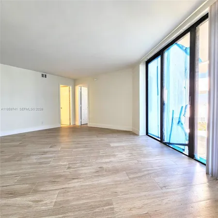 a view of an empty room with glass door and balcony