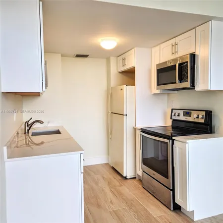 a kitchen with stainless steel appliances granite countertop a refrigerator stove top oven and sink