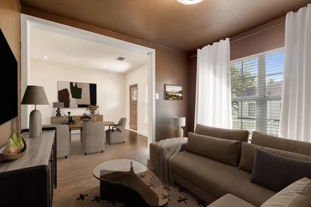 a living room with furniture wooden floor and a large window