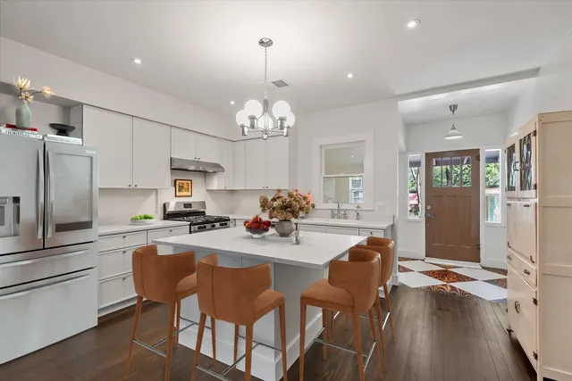 a view of a dining room and livingroom with furniture wooden floor a chandelier