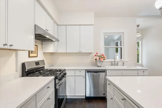 a kitchen with white cabinets and white appliances