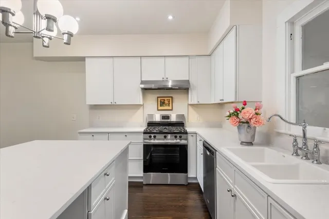a kitchen with a stove sink and cabinets
