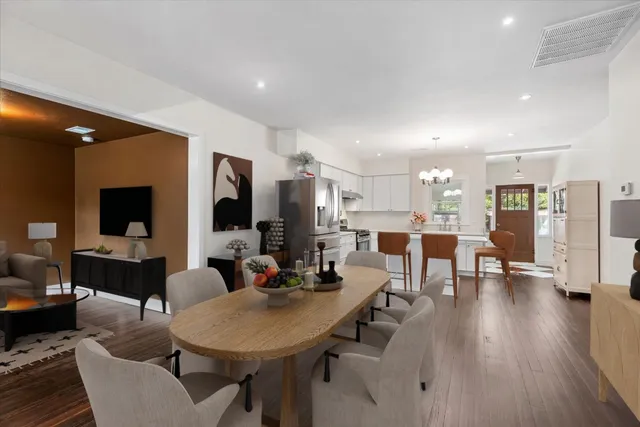 a living room with furniture kitchen view and a wooden floor
