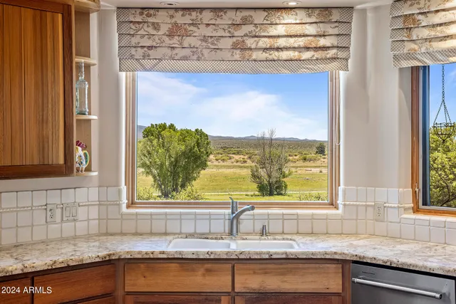 a kitchen with stainless steel appliances granite countertop a stove top oven a sink and a refrigerator