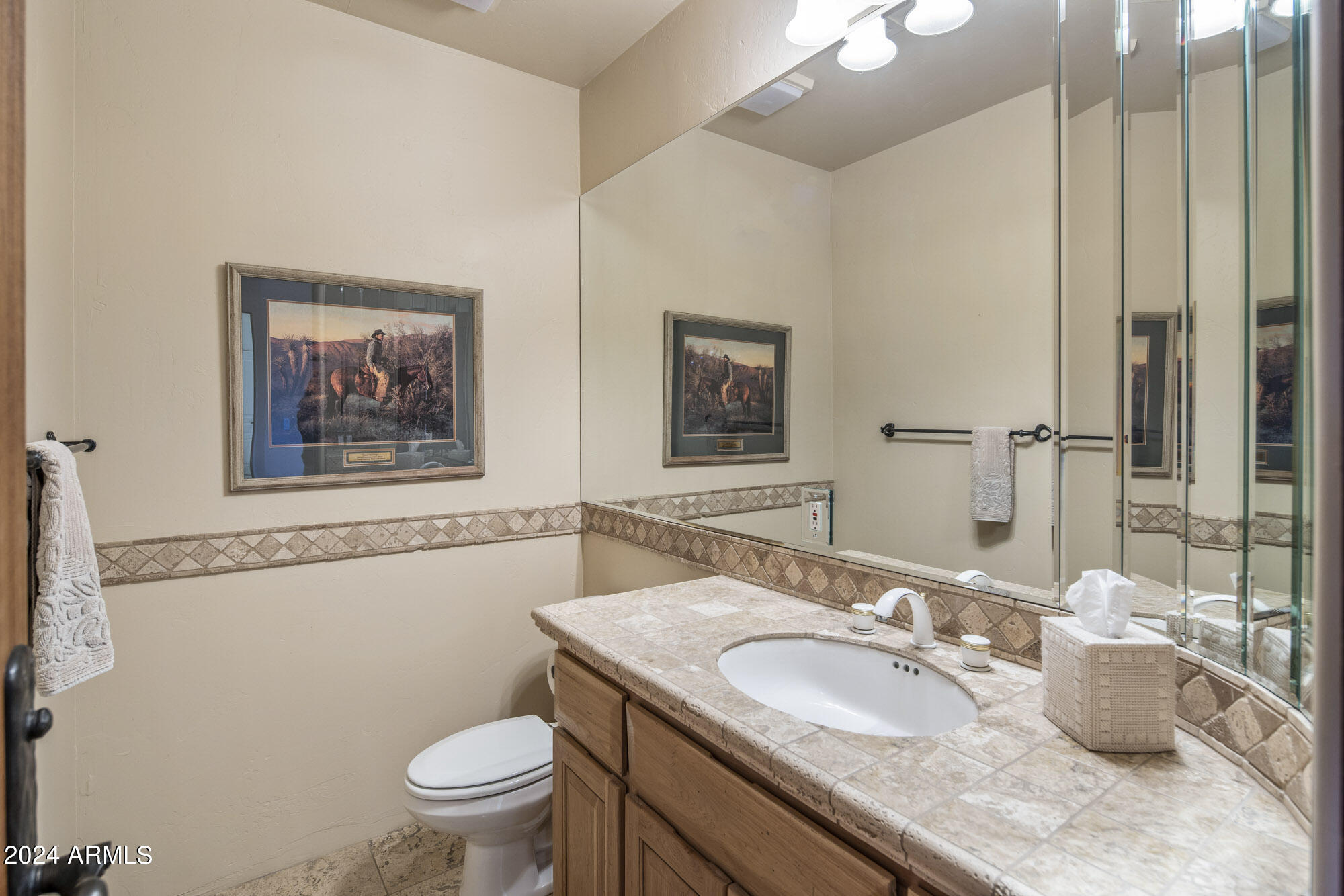 5500 Four Cross Ranch Road Skull Valley, AZ 86338 - Photo 15 of 59 a bathroom with a granite countertop toilet a sink and a mirror