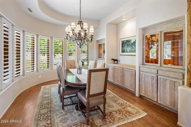 a spacious bedroom with a bed a couch and a chandelier