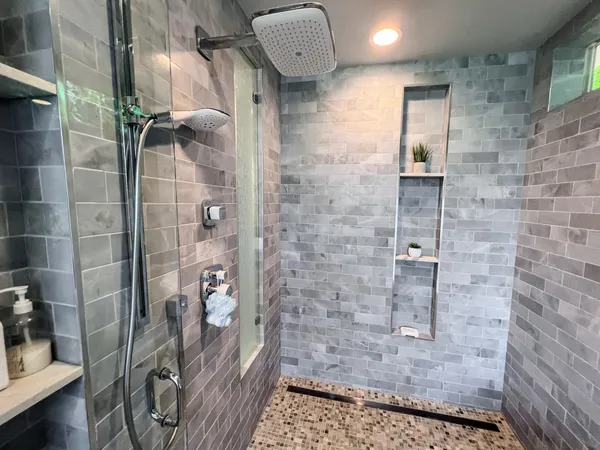 a bathroom with a double vanity sink toilet mirror and shower
