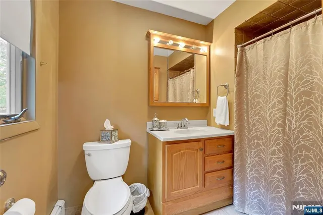 a bathroom with a granite countertop toilet sink and mirror