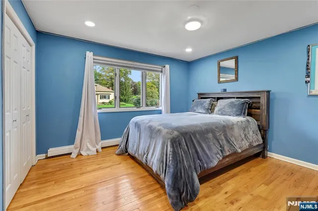 a bed sitting in a spacious bedroom next to a window