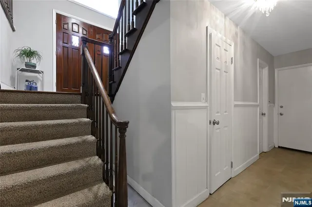 a view of staircase with lots of frames on wall and a window