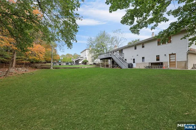 a white house with a big yard and large trees