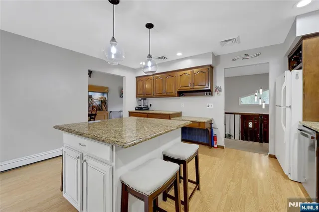 a kitchen with stainless steel appliances granite countertop a kitchen island a stove and a sink