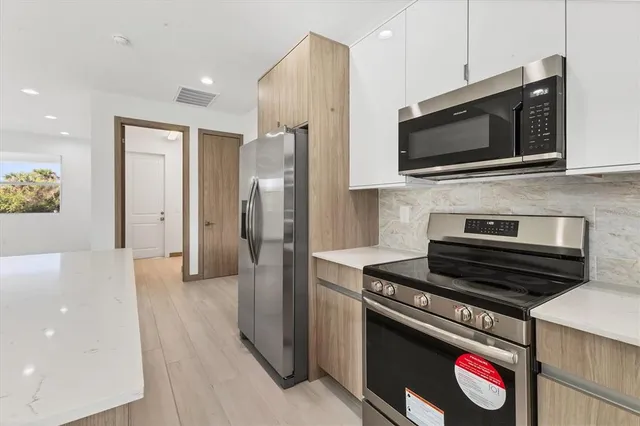 a kitchen with stainless steel appliances kitchen island a stove and a microwave