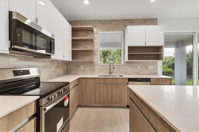 a kitchen with stainless steel appliances a sink stove and microwave