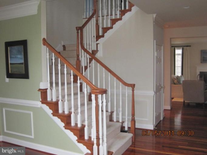10811 Catron Road Perry Hall, MD 21128 - Photo 8 of 30 a view of staircase with lots of frames on wall and wooden floor