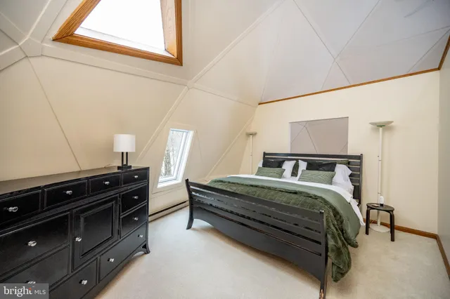 a bedroom with a bed couch and a window