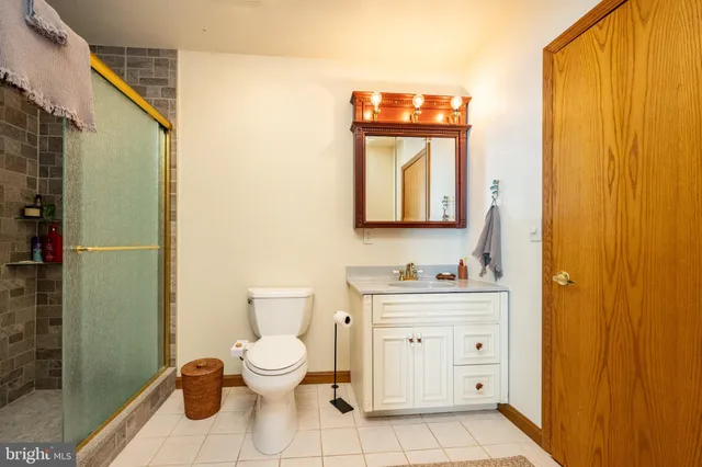 a view of a patio with table and chairs with wooden fence and large trees
