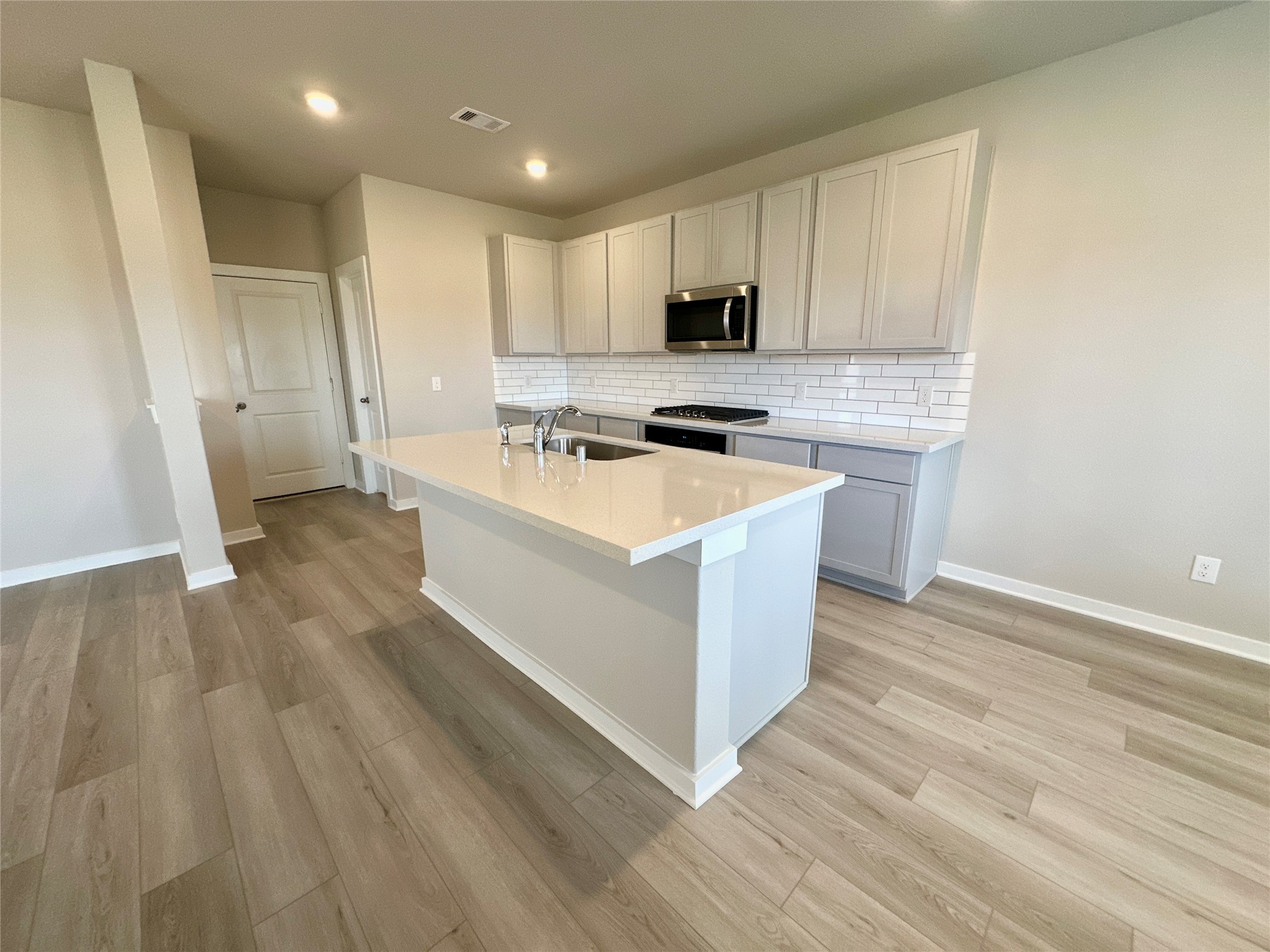 12176 Ridge Top Drive Conroe, TX 77304 - Photo 6 of 27 a large kitchen with stainless steel appliances a white stove top oven and white cabinets