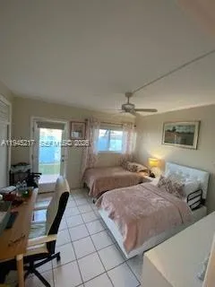 a bedroom with two beds and a lamp on dresser