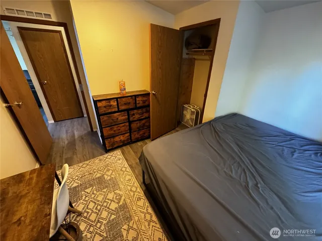 a bedroom with a bed and wooden floor