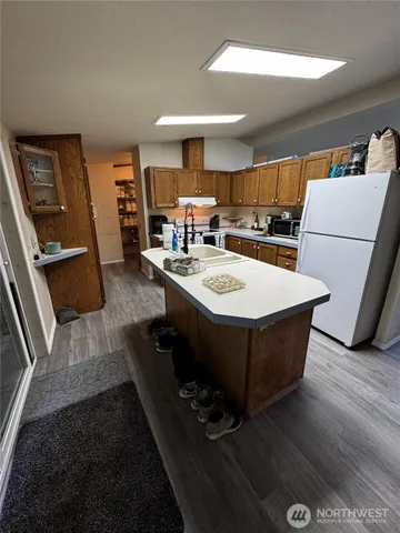 a living room with stainless steel appliances furniture a rug and a large window
