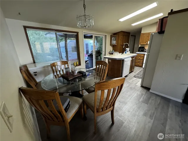 a dining room with furniture a chandelier and wooden floor