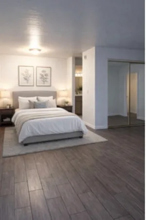 a bedroom with a large bed and wooden floor