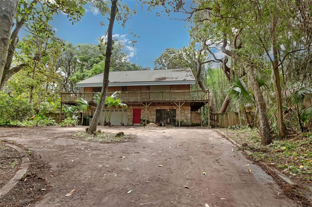 a view of a house with a tree and a forest