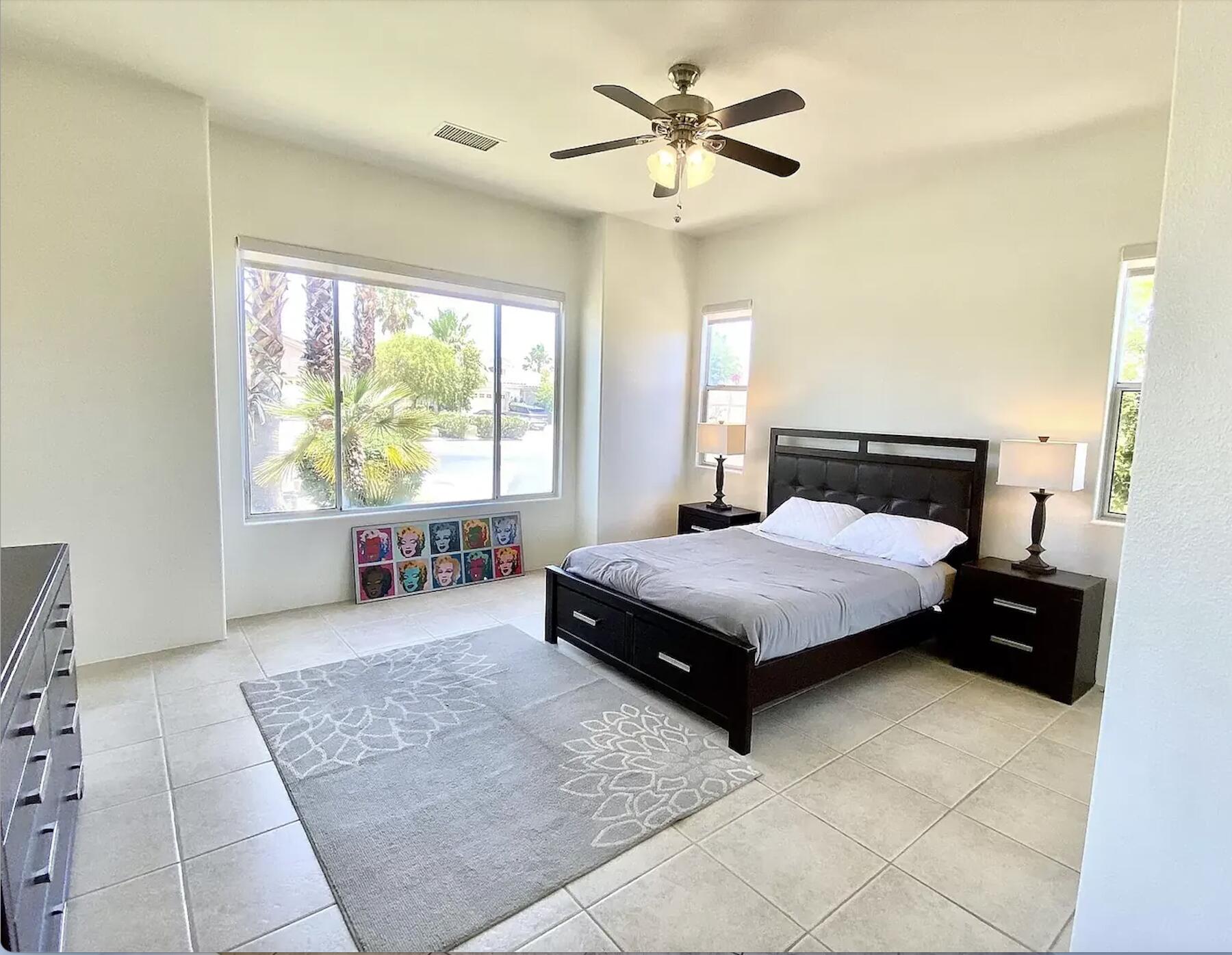 5 Victoria Falls Drive Rancho Mirage, CA 92270 - Photo 23 of 26 a bedroom with a bed and a chandelier