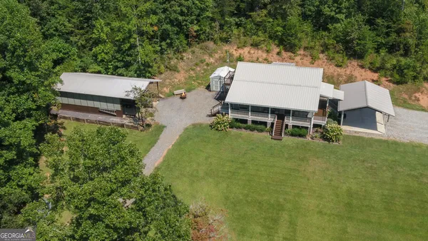 an aerial view of a house with pool and yard
