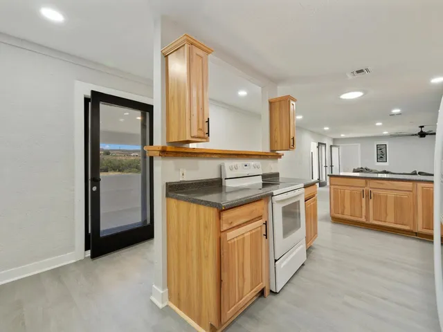 a kitchen with stainless steel appliances granite countertop a stove a sink and a refrigerator