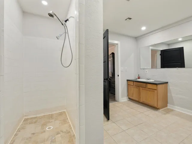 a bathroom with a granite countertop sink a mirror and a shower