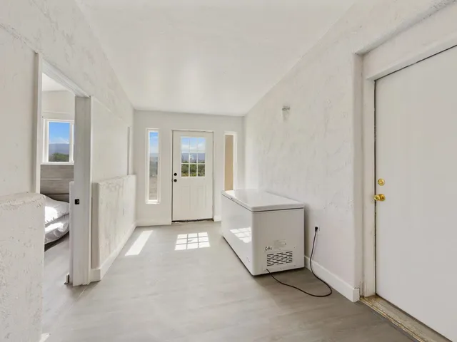 a view of an empty room and a bathroom with a sink