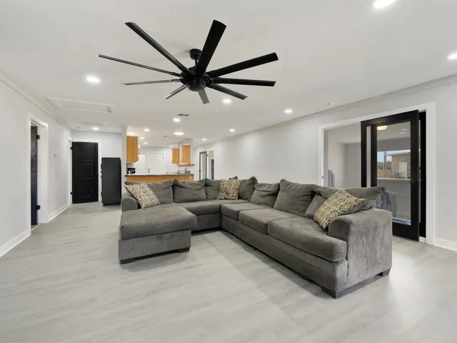 a living room with furniture and a ceiling fan