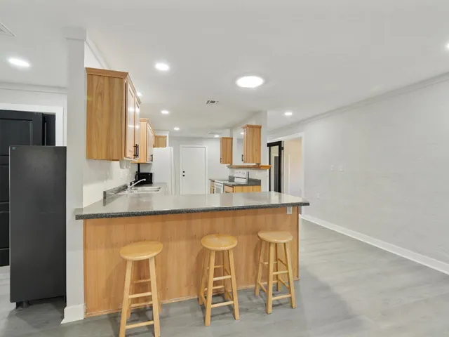 a kitchen with stainless steel appliances granite countertop a sink and a refrigerator