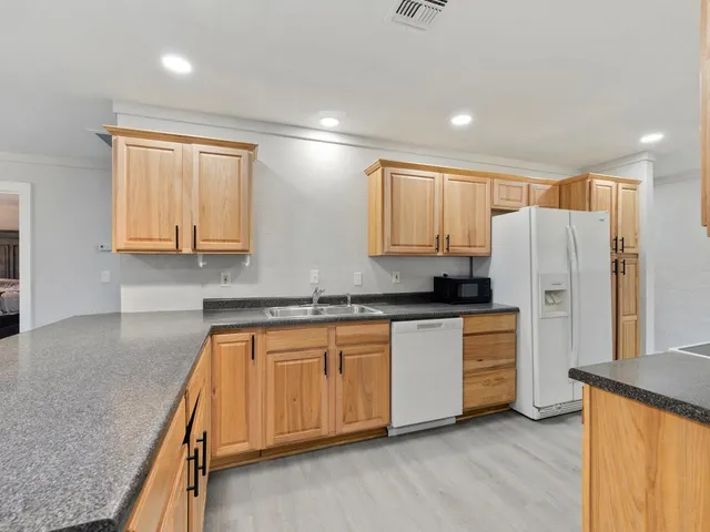 a kitchen with stainless steel appliances granite countertop a refrigerator sink and cabinets