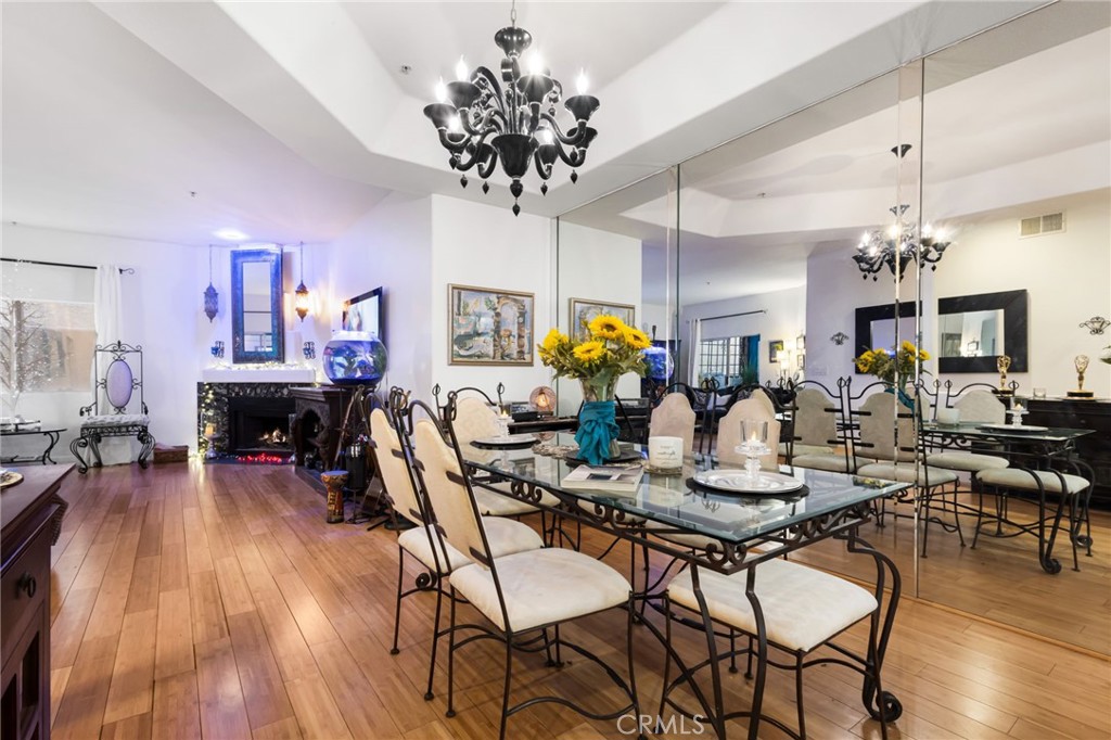 10626 Valley Spring Lane, Unit 103 Toluca Lake, CA 91602 - Photo 12 of 44 a view of a dining room with furniture wooden floor and chandelier