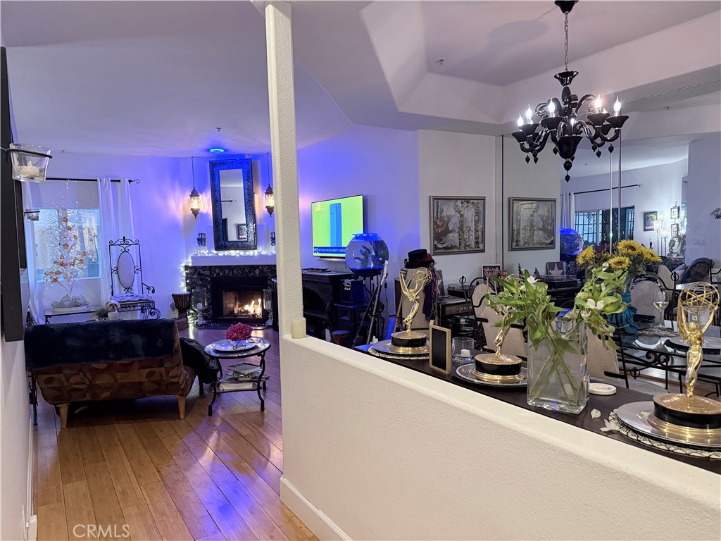 10626 Valley Spring Lane, Unit 103 Toluca Lake, CA 91602 - Photo 13 of 13 a living room with fireplace furniture and a chandelier