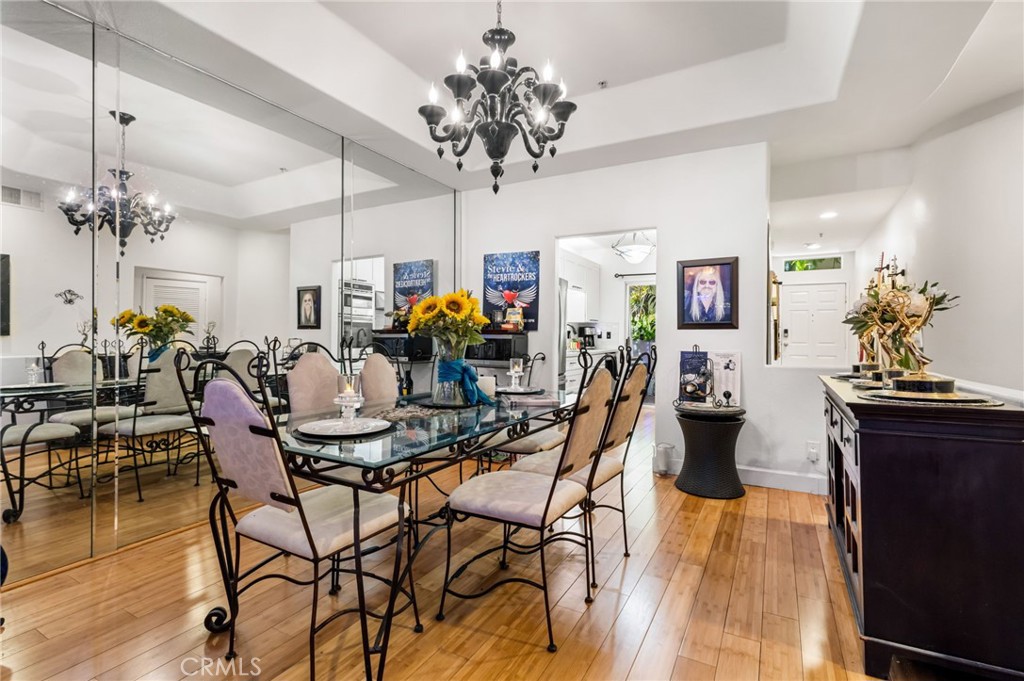 10626 Valley Spring Lane, Unit 103 Toluca Lake, CA 91602 - Photo 13 of 67 a view of a dining room and livingroom with furniture wooden floor a chandelier